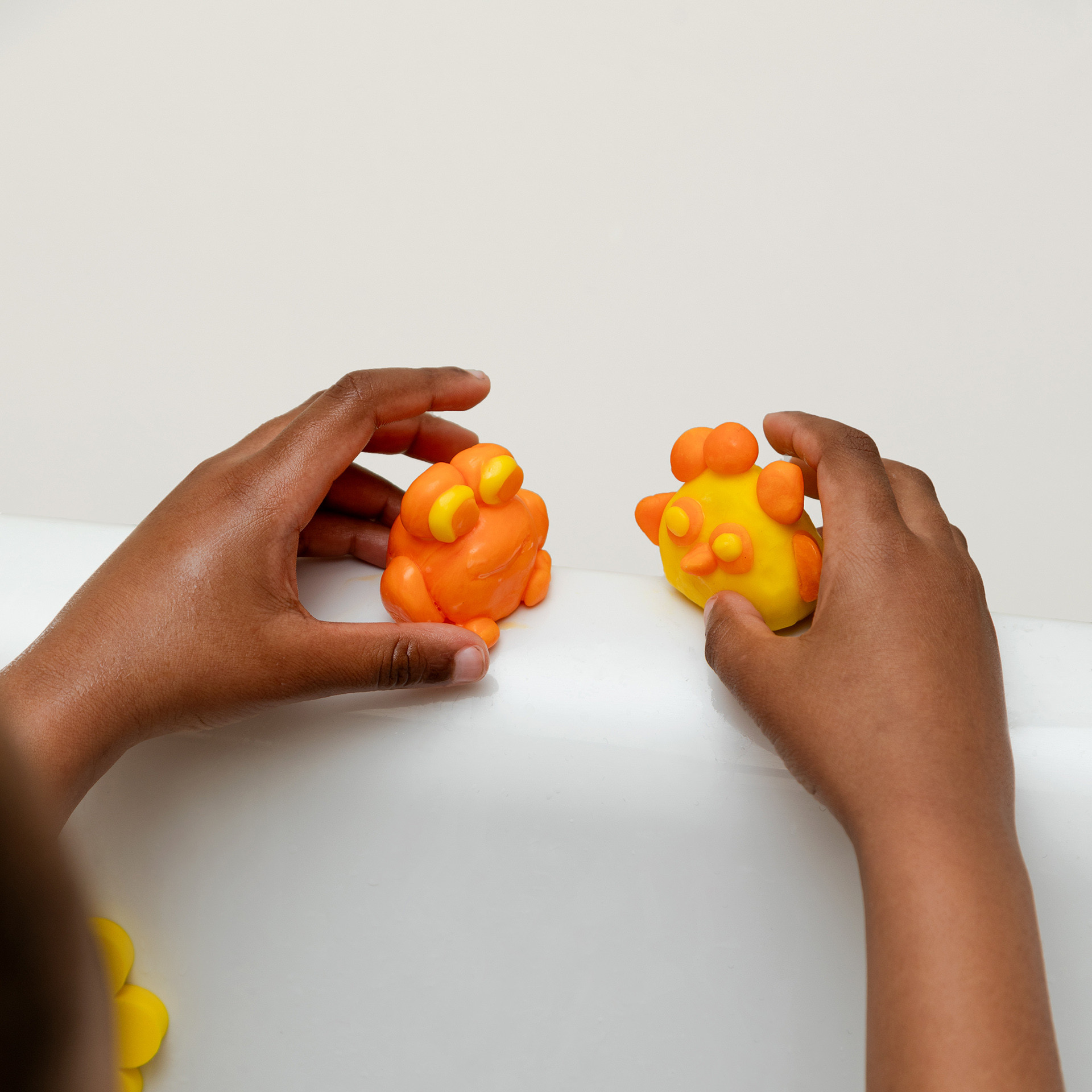 Poussin et grenouille en pâte à modeler jaune et orange pour s'amuser dans le bain